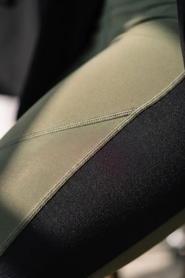 detail: Black blazer over an olive sports top and panelled leggings