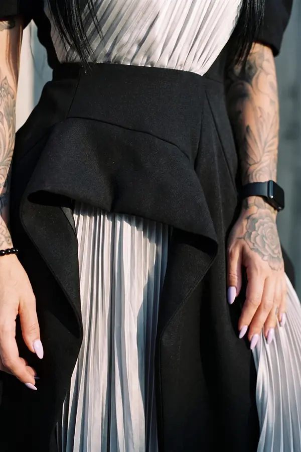 detail: Black puff-sleeve dress with pleated silver panels