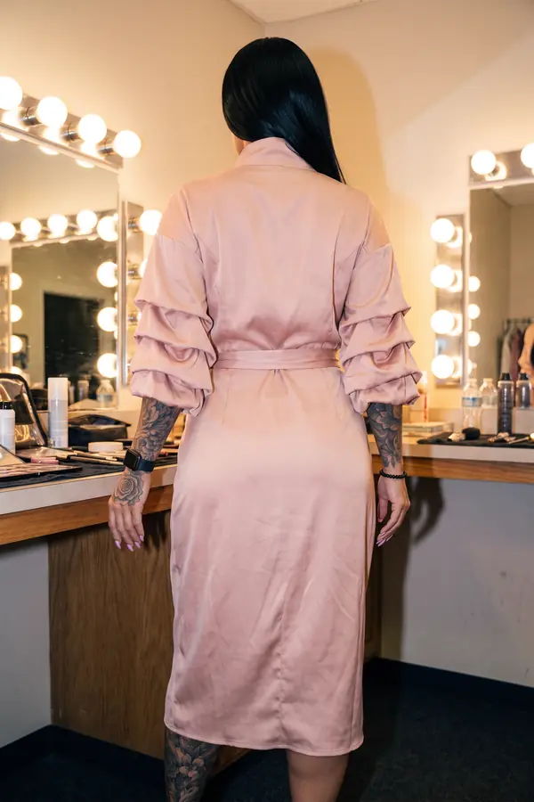 back & profile: Blush satin funnel-neck dress with ruched sleeves
