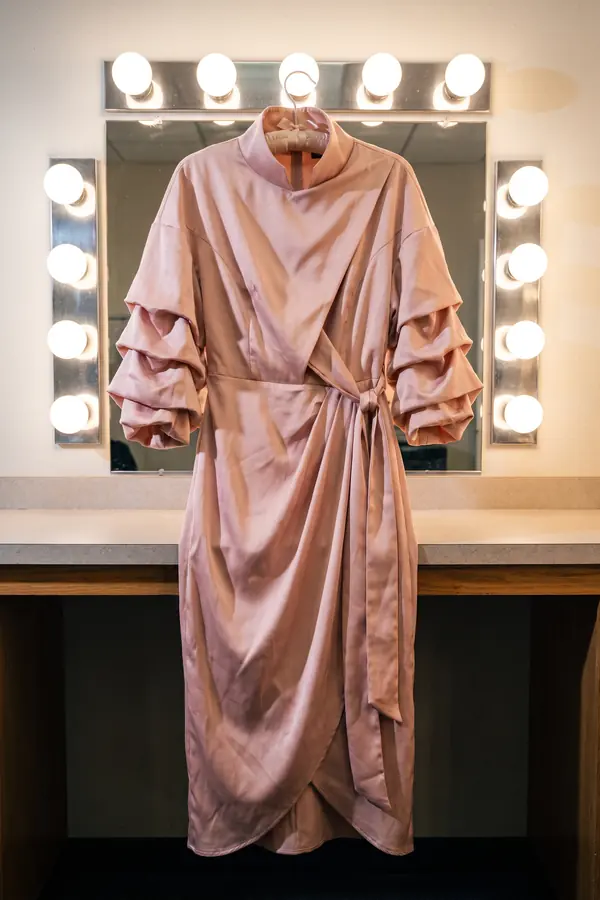 still life: Blush satin funnel-neck dress with ruched sleeves