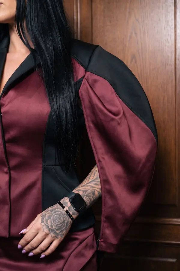 detail: Burgundy and black satin cape jacket with a mini skirt