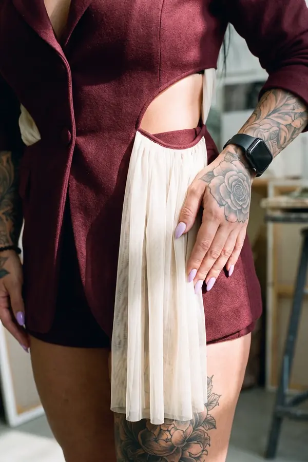 detail: Burgundy cut-out blazer with tulle sash and tailored shorts