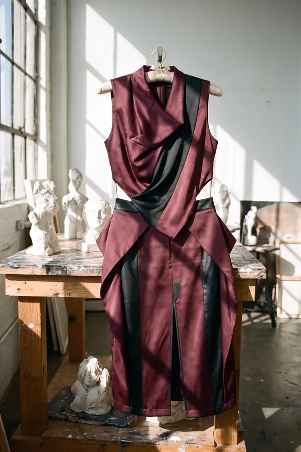 still life: Burgundy draped satin dress with black leather panels