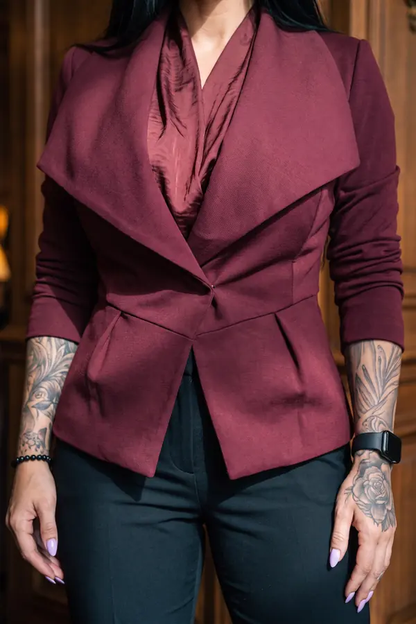 detail: Burgundy peplum blazer with satin blouse and black trousers