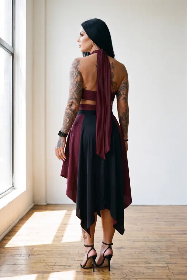 back & profile: Burgundy pleated crossover top and colour-block satin skirt