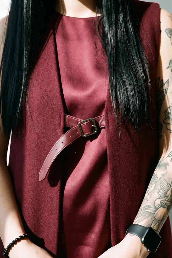 detail: Burgundy satin dress with a wool overlay and leather straps