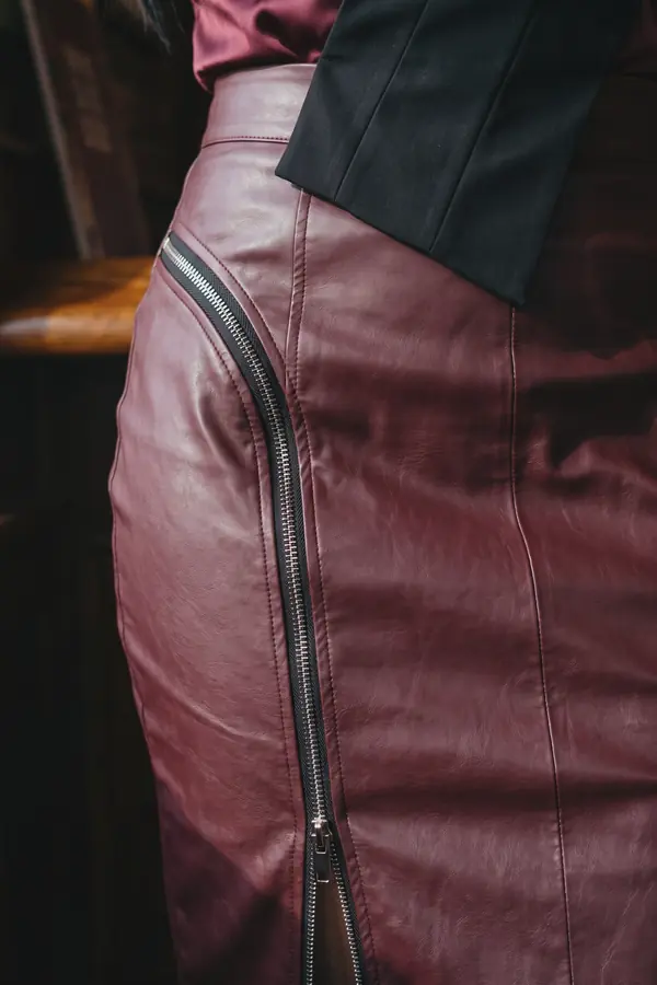 detail: Burgundy satin one-shoulder top and leather zip pencil skirt