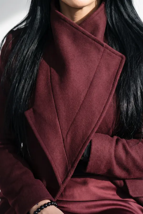 detail: Burgundy wool asymmetric coat over a satin midi skirt