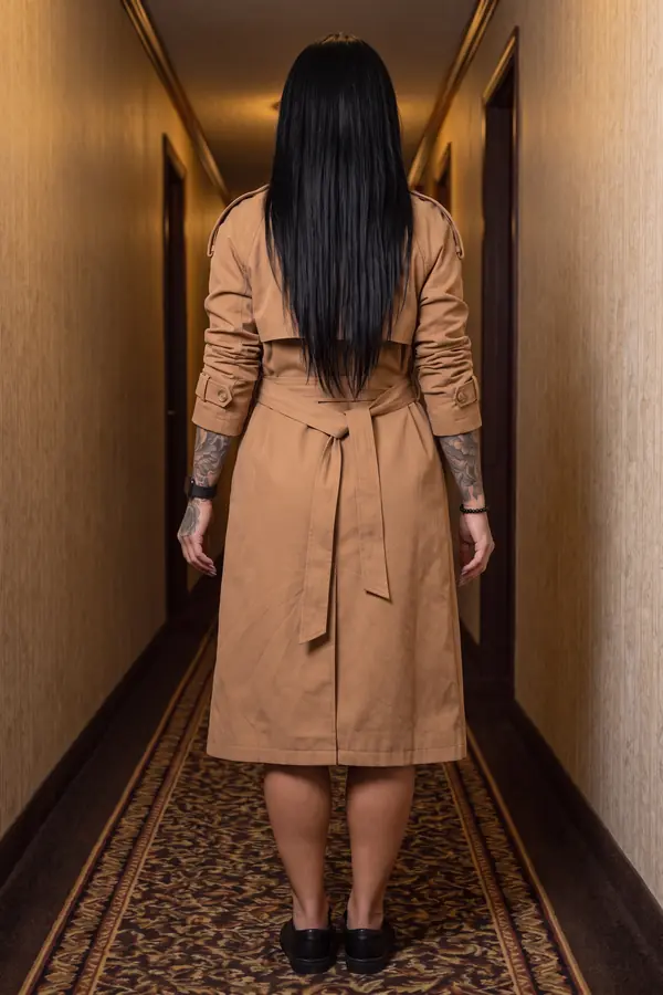 back & profile: Camel cotton trench coat worn closed and belted