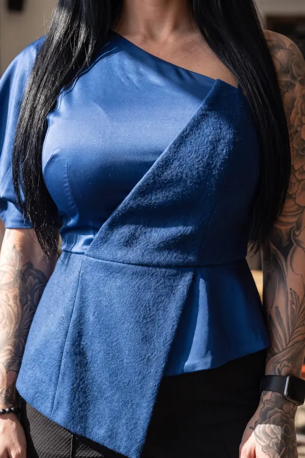 detail: Cobalt one-shoulder peplum top with black slim trousers