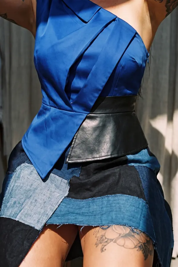 detail: Cobalt one-shoulder satin top with a patchwork denim skirt