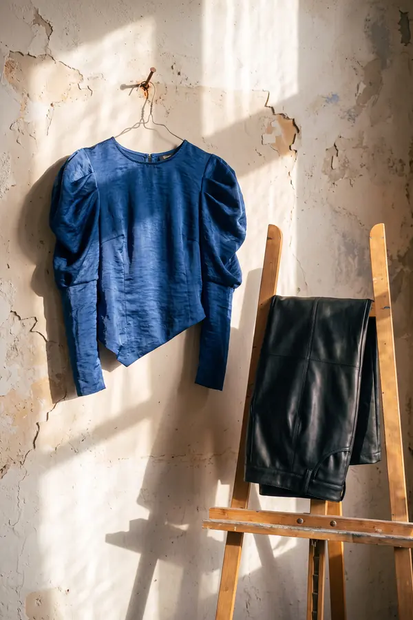 still life: Cobalt puff-sleeve satin blouse with black leather trousers