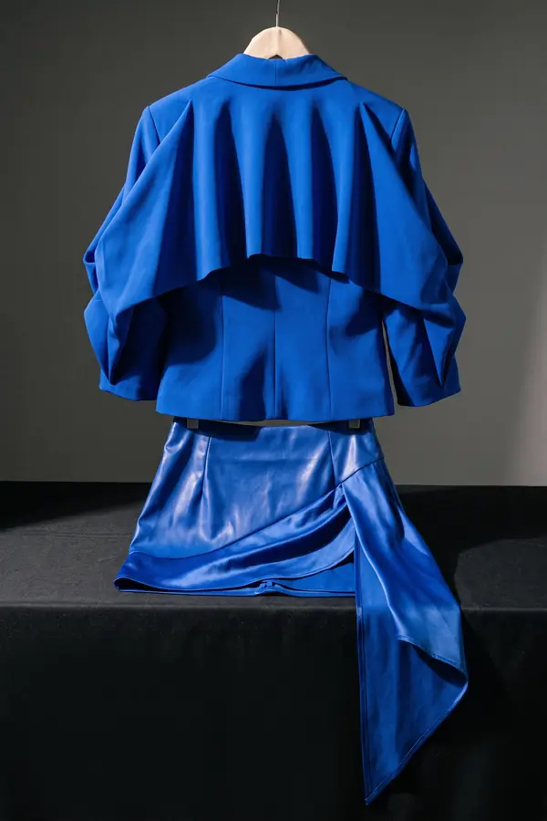 still life: Cobalt ruffle-back jacket with a draped leather mini skirt