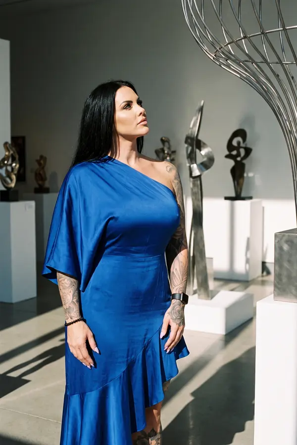 full look: Cobalt satin one-shoulder dress with a cape sleeve