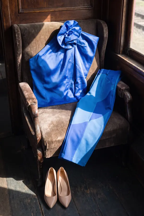 still life: Cobalt satin rosette top with colour-block trousers