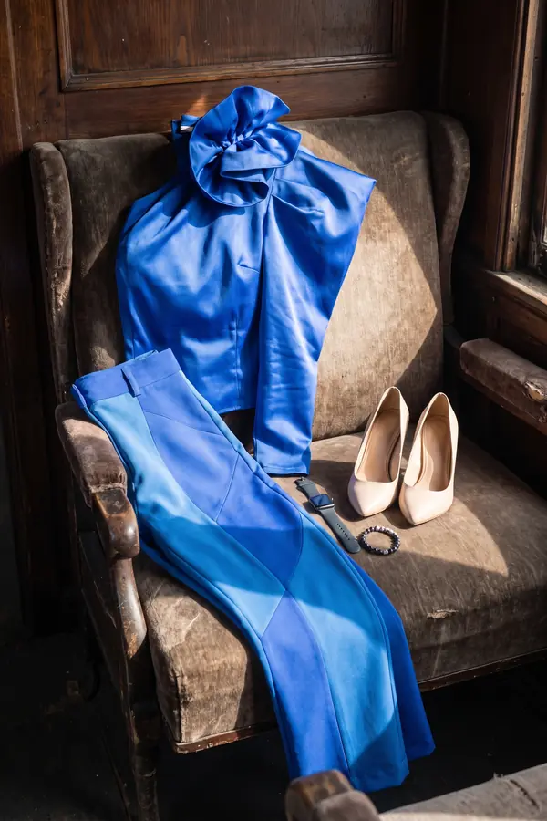 still life: Cobalt satin rosette top with colour-block trousers