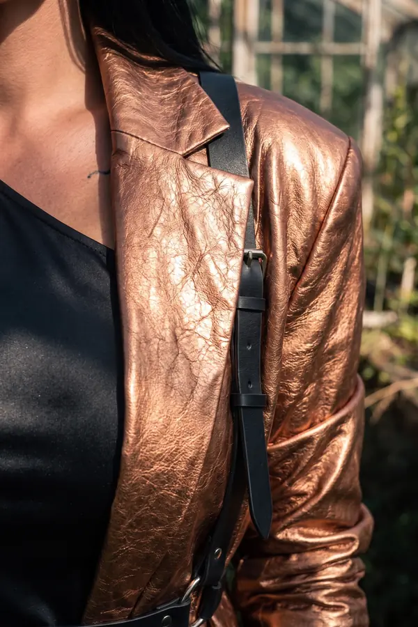 detail: Copper leather blazer with shoulder-strap belt and cargo trousers