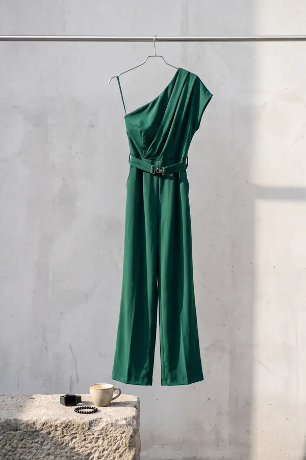 still life: Emerald one-shoulder draped jumpsuit with buckled belt