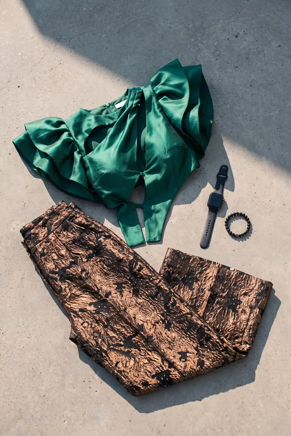 still life: Emerald ruffle cut-out top with bronze brocade trousers