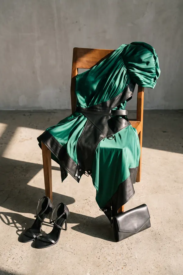 still life: Emerald satin one-shoulder dress with leather corset panel