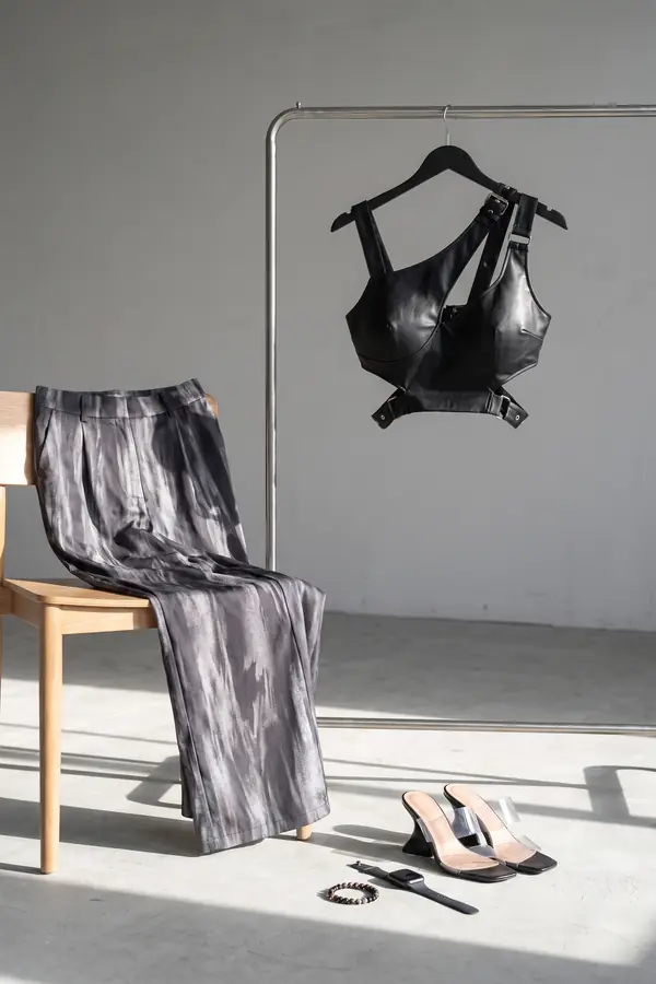 still life: Leather buckle crop top with marbled grey wide-leg trousers