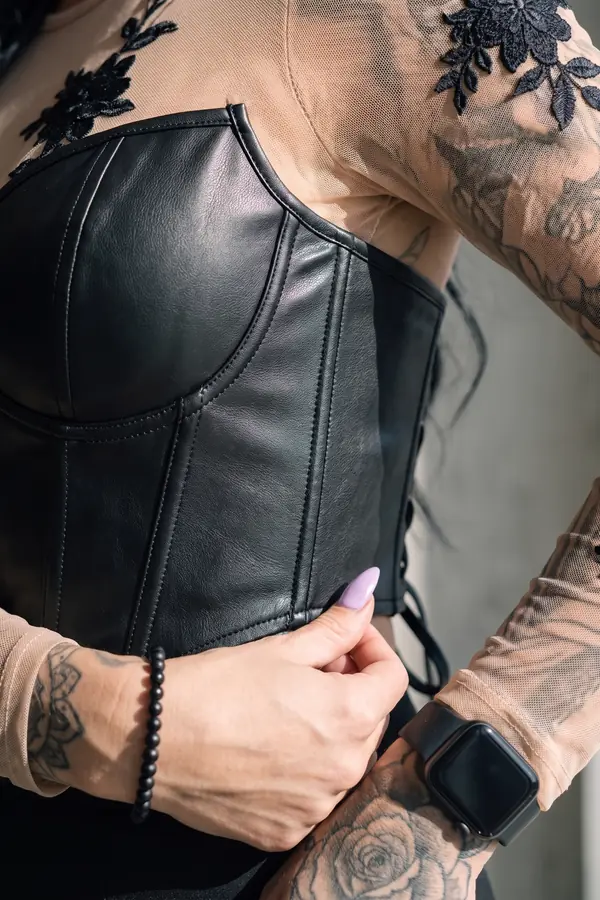 detail: Leather corset, lace mesh top and cut-out wide-leg trousers