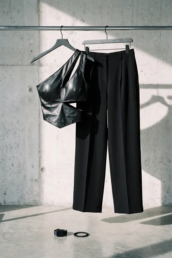 still life: Leather one-shoulder cut-out bodysuit with pleated trousers