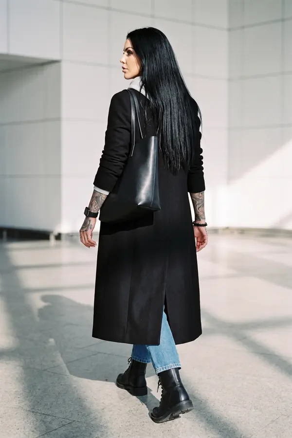 back & profile: Long black wool coat over a grey hoodie and straight jeans