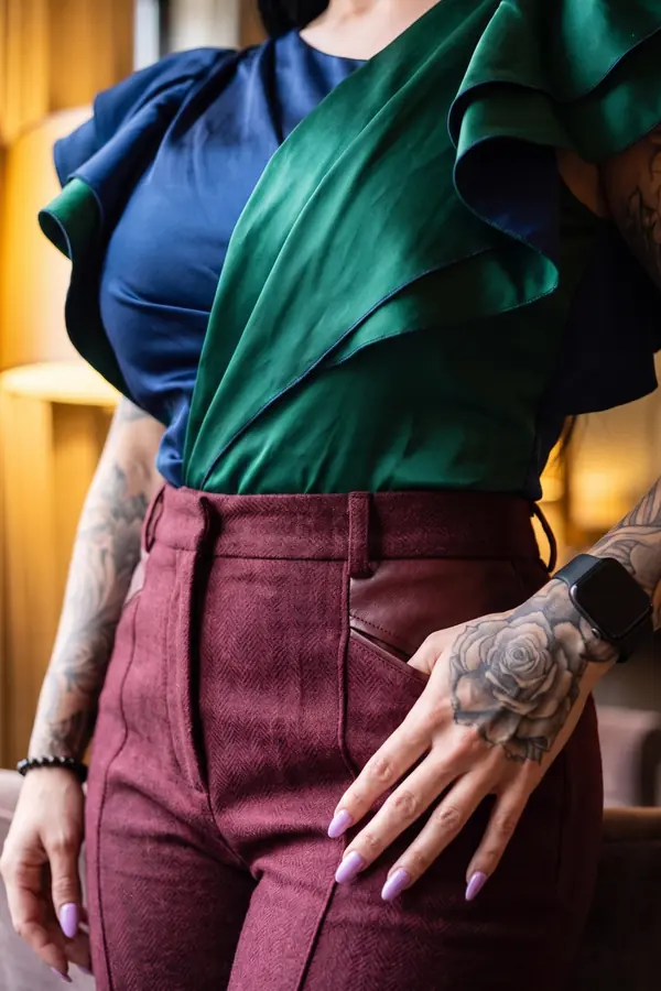 detail: Navy and emerald ruffle top with burgundy wool trousers