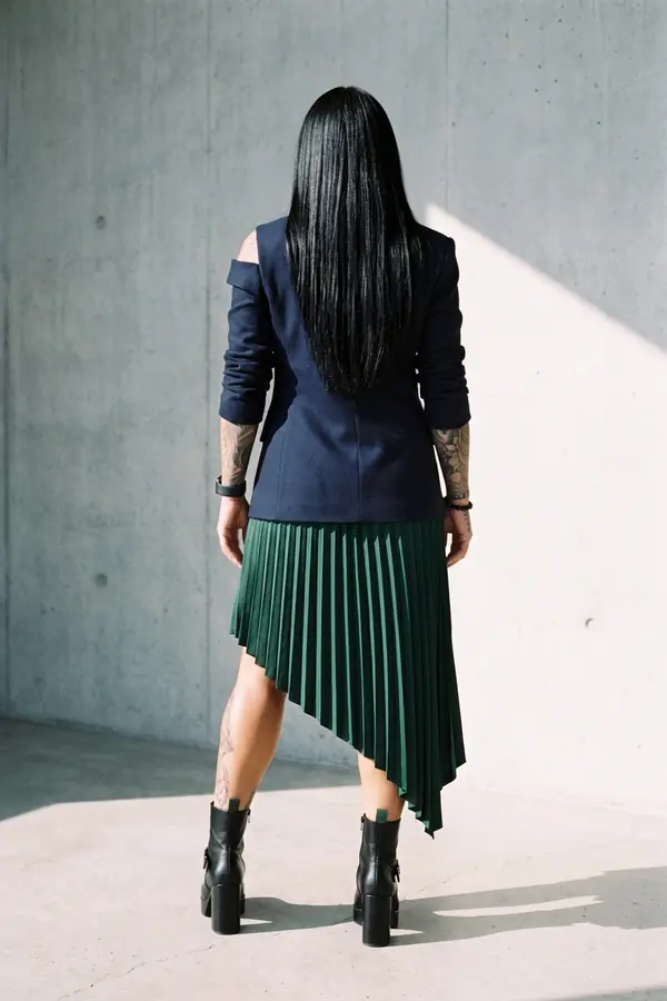 back & profile: Navy cut-out shoulder blazer with an emerald pleated skirt