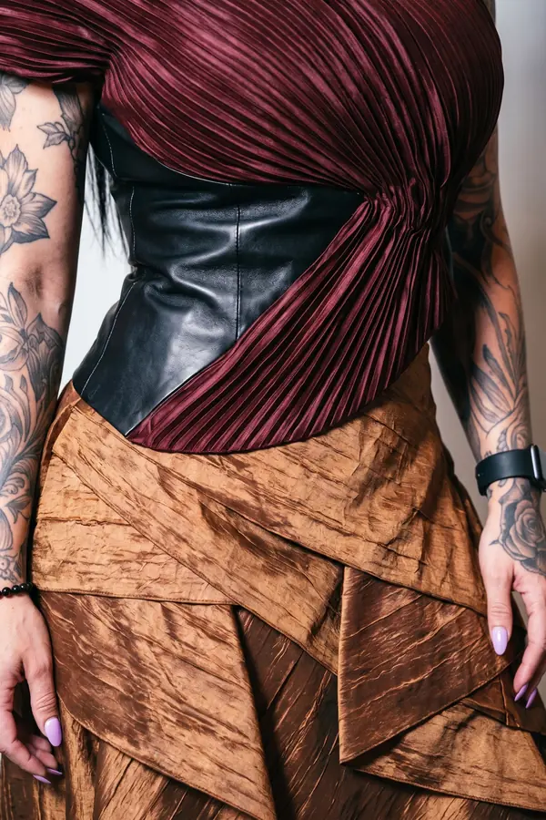 detail: Oxblood plissé top with a leather corset and taffeta skirt
