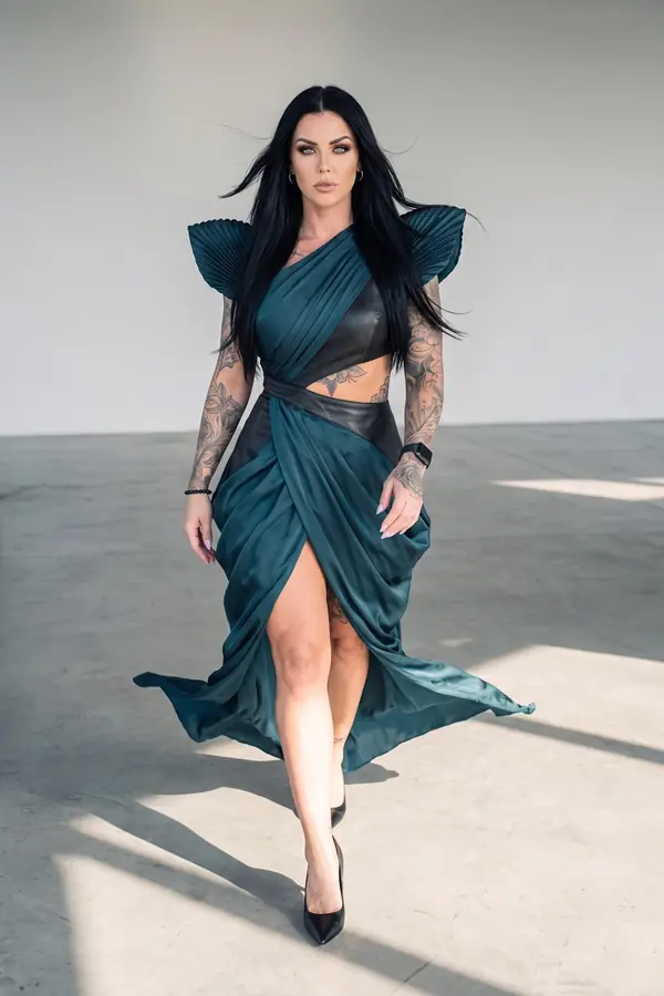 in motion: Petrol satin and leather gown with pleated shoulders