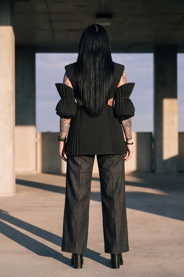 back & profile: Pleated-sleeve sleeveless blazer and black denim trousers