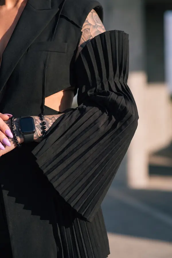 detail: Pleated-sleeve sleeveless blazer and black denim trousers