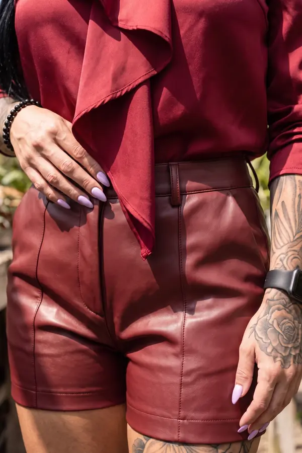 detail: Red satin jabot blouse with oxblood leather shorts