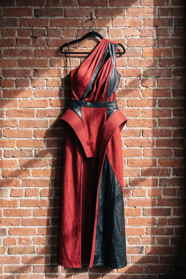 still life: Red suede one-shoulder gown with black leather panels
